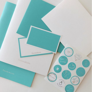 シンプルなホワイトとブルーにシルバーの箔押しがポイント。　“１００円で暮らしは楽しくなる。“