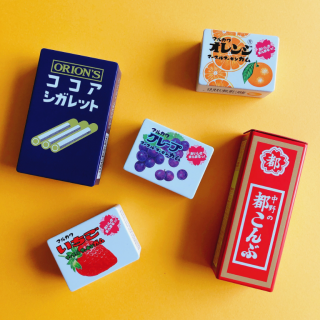 昔ながらの懐かしい駄菓子のパッケージをそのまま缶ケースにしました。　“１００円で暮らしは楽しくなる“