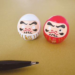 願いを込めてだるまに目を入れよう。　“１００円で暮らしは楽しくなる“