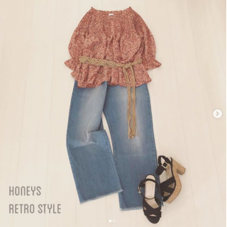 花柄のブラウスはデニムのワイドパンツとマクラメベルトで少しレトロな雰囲気でコーディネート 　足元には黒のサンダルを合わせてアクセントに