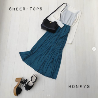 プリーツのシアートップスにあえて濃い色のインナーを合わせてシアー感を楽しむスタイリングに キレイ色のスカートを合わせたフェミニンスタイルに