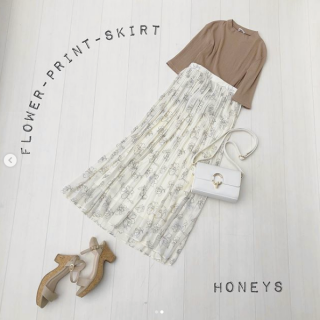 線描きの花柄スカートを主役にした大人ガーリースタイル トップスのキャメルとサンダルのベージュを差し色に
